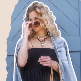 blonde woman wearing black dress, sunglasses and denim jacket